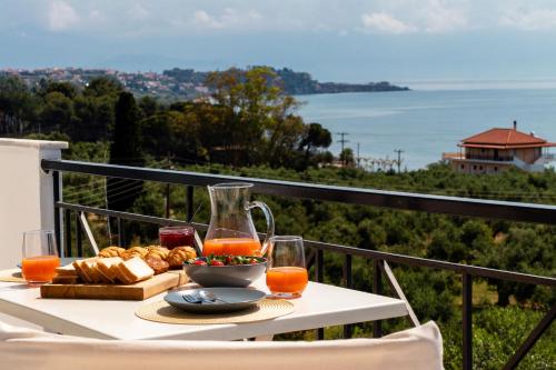 una mesa con un plato de comida y zumo de naranja en Koroni Xenios Zeus, Seaview Summer Retreats, en Koroni