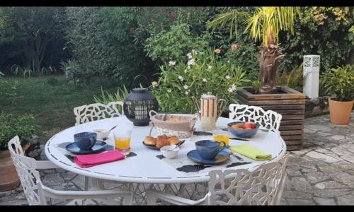 une table blanche avec des assiettes de nourriture dans l'établissement d’un jardin à l’autre, à Tarbes