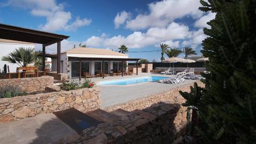 uma villa com uma piscina e uma casa em Pueblo Canario em Los Estancos