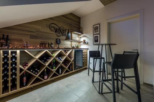 a bar with two chairs and a counter with wine bottles at Villa The View Opatija in Opatija