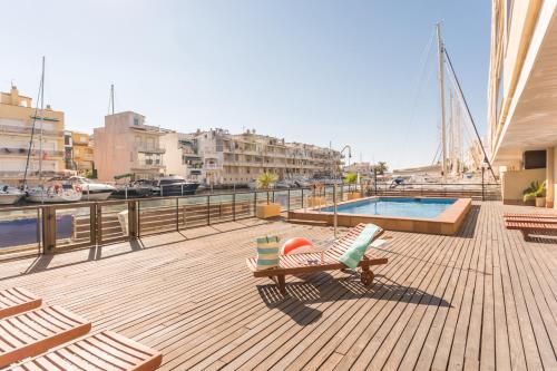 a deck with a chair and a pool on a boat at Pierre & Vacances Empuriabrava Marina in Empuriabrava