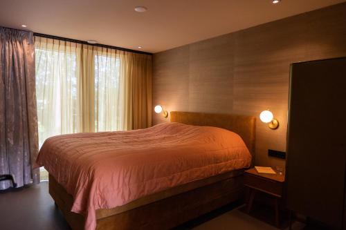 a bedroom with a bed and a large window at Residenties en bungalow Royal Domburg in Domburg