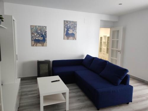 a living room with a blue couch and a table at Piso marinero in Muxia