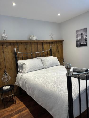 a bedroom with a bed with a wooden headboard at 2 hunters lane Donaghadee in Donaghadee