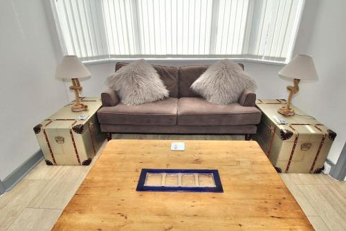 a living room with a couch and two tables with lamps at BRiSYL BEACH HOUSE, with amazing changing views! in Kent