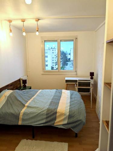 una camera con letto, scrivania e finestra di Appartement 3 Chambres - 78m2 - Lumineux a Bihorel