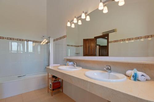 a bathroom with two sinks and a large mirror at Villa Nathalie in Jávea