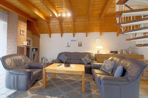 uma sala de estar com dois sofás de couro e uma mesa em Strandvogt 2 OH29 em Dorum Neufeld