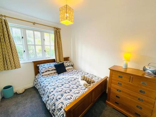 a bedroom with a bed and a dresser and a window at Centrally located "Spring Cottage" Perfect Ventnor Holiday Home in Ventnor