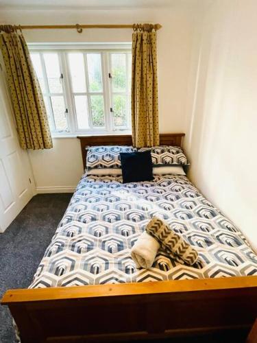a bedroom with a bed with a laptop on it at Centrally located "Spring Cottage" Perfect Ventnor Holiday Home in Ventnor