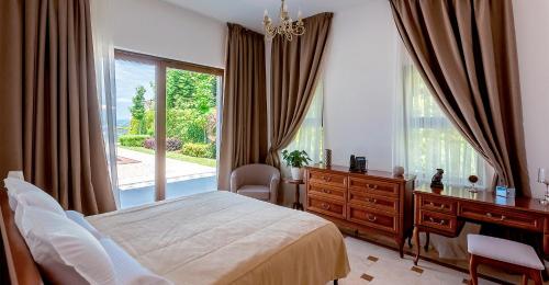a bedroom with a bed and a desk and a window at Oak Leaf Residences in Budva