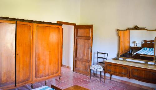 una camera da letto con cassettiera in legno e specchio di Agriturismo il Vecchio Pozzo a Casa Affitti