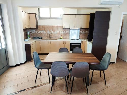 a kitchen with a wooden table and four chairs at Golden Sunrise - Nikos Home in Gythio