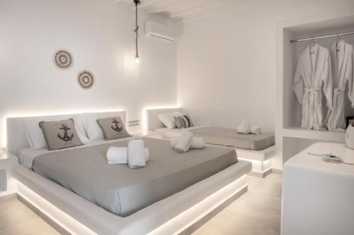 a white bedroom with two beds in it at Feel Breeze in Mikonos