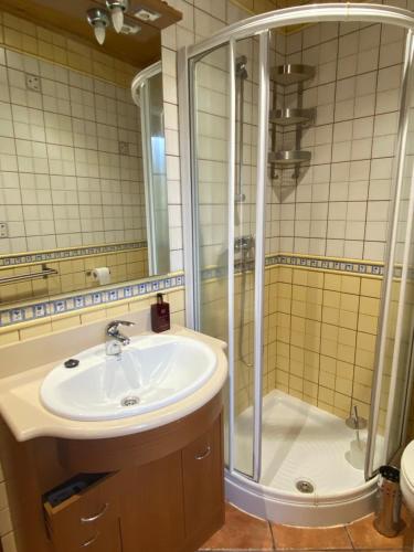 ein Bad mit einem Waschbecken und einer Dusche in der Unterkunft Villa Maribel in Foz