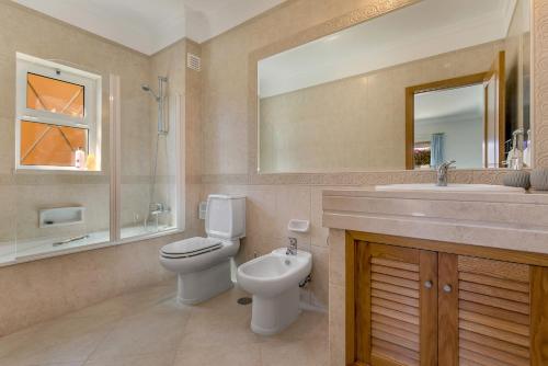 een badkamer met een toilet, een wastafel en een spiegel bij Lakeview Paradise by LovelyStay in Lagos