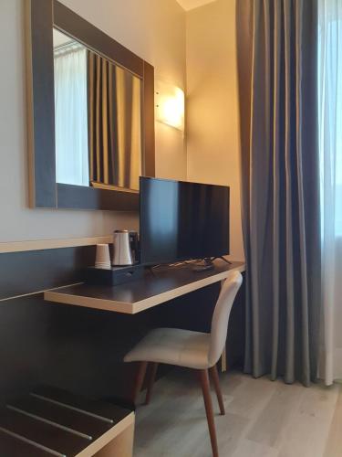 a desk with a monitor and a chair in a room at Hotel Ristorante Al Mulino by LVG Hotel Collection in Alessandria