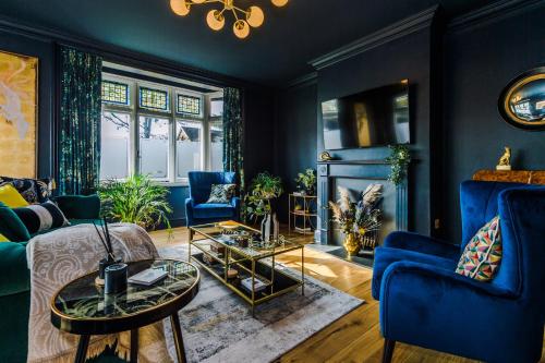 a living room with blue furniture and a fireplace at The Windsor Tapestries Retreat - Sleeps up to 9, Hot Tub, Free Parking, Dog Friendly in Windsor