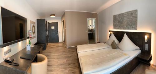 a bedroom with a large bed and a desk at Campushotel in Hagen