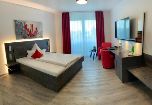 a bedroom with a bed and a desk and a television at Campushotel in Hagen