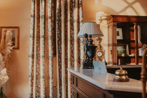 a lamp on a dresser in a room with a curtain at Agriturismo Terra Di Dio Toscanizzazione in Capannoli