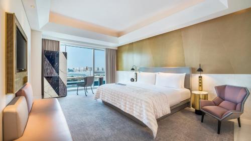 una camera d'albergo con letto e sedia di Le Meridien Shanghai Hongqiao,Minhang a Shanghai