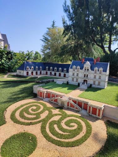 une grande maison avec un jardin en spirale en face de celle-ci dans l'établissement Monts repos!, à Monts