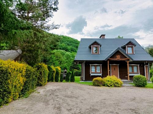 a house with a gravel driveway in front of it at Domki w Bieszczadach in Polańczyk