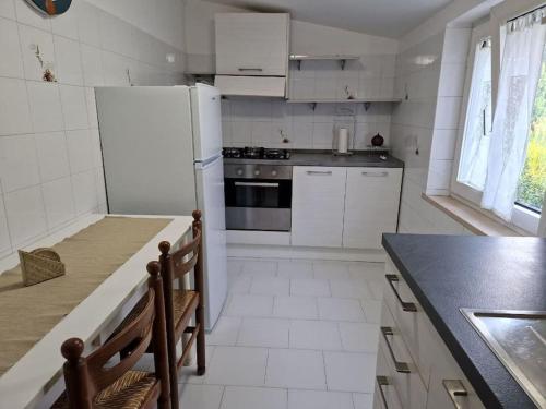 a kitchen with white appliances and a black counter top at La casetta di Flo in Montecosaro