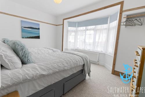 a bedroom with a bed and a large window at Seaway Garden in Paignton