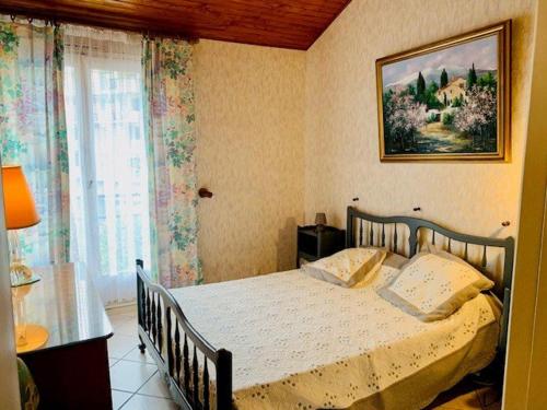 阿梅利莱班帕拉勒达Appartement F2 climatisé avec terrasse, parking, à 600m des thermes - Amélie-les-Bains - FR-1-703-27的卧室里有一张床，墙上挂着一幅画