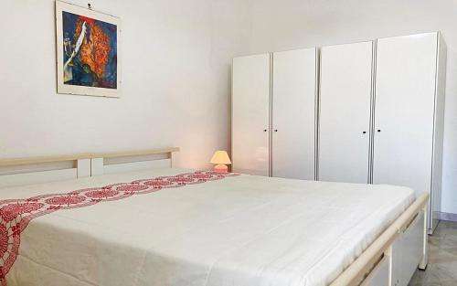 ein weißes Schlafzimmer mit einem großen Bett und weißen Schränken in der Unterkunft Villetta Torre Vado in Torre Vado