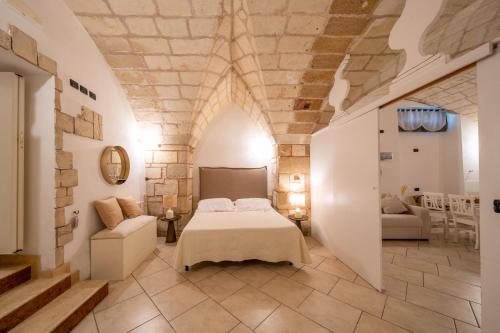 a bedroom with a bed and a couch in a room at Leondari Rooms V Collection Otranto in Otranto