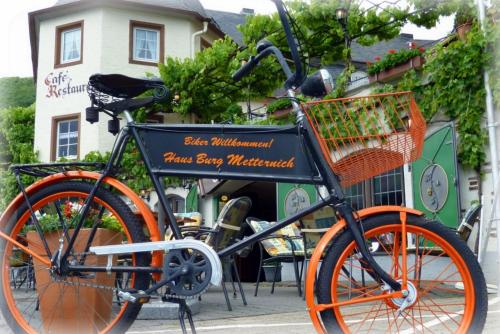 an orange bike parked in front of a building at Hotel Haus Burg Metternich in Beilstein