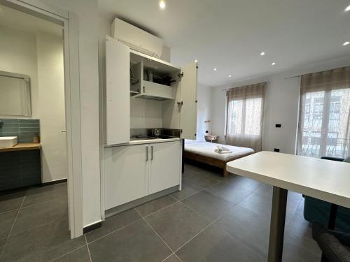 a kitchen with white cabinets and a table in a room at NG Guest House il Gallura in Olbia