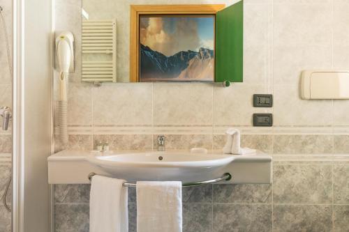 a bathroom with a sink and a painting on the wall at Hotel City Verona in San Giovanni Lupatoto