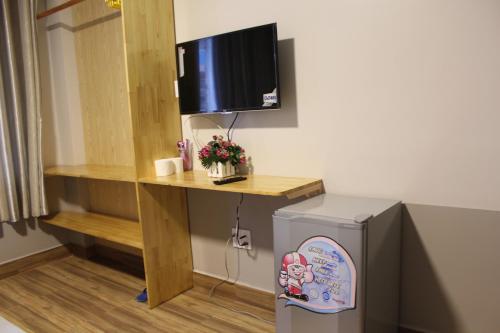 a room with a desk and a television and a refrigerator at DaLat Sky Hostel in Da Lat