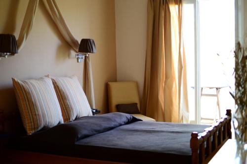 een slaapkamer met een bed en een raam met bij Petalidi in Skala Mistegnon