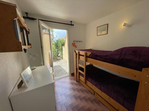 sypialnia z łóżkiem i przesuwanymi drzwiami szklanymi w obiekcie T3 calme avec terrasse, clim et parking proche plage - FR-1-106-45 w mieście Saint-Cyprien