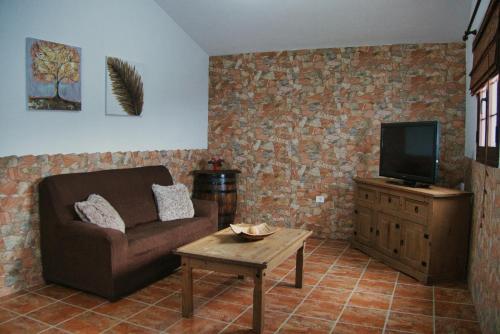 a living room with a couch and a tv at Vivienda vacacional el Aljibe in Mocanal