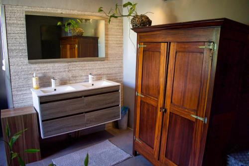 a bathroom with a sink and a wooden cabinet at Casa Babalahy in Saint-Pierre