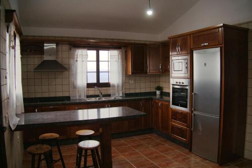 莫卡諾爾的住宿－Vivienda vacacional el Aljibe，厨房配有木制橱柜和不锈钢冰箱。