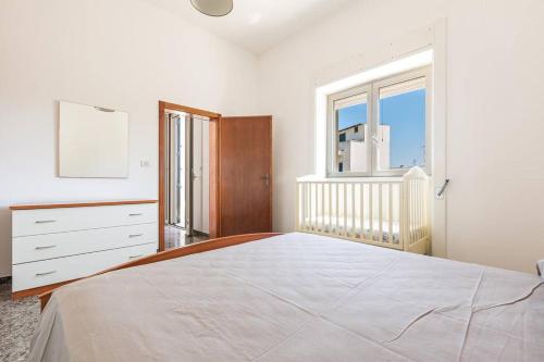 a white bedroom with a large bed and a window at Salentoandmore - Bilocale Sole in Marina di Leuca