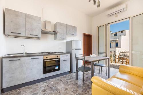 a kitchen and dining room with a table and a couch at Salentoandmore - Bilocale Sole in Marina di Leuca