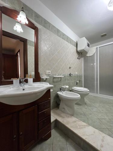 a bathroom with a sink and a toilet and a mirror at Vicolo 35 Apartments in Trapani