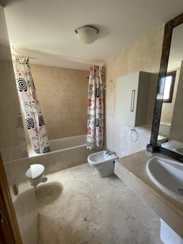een badkamer met een wastafel, een toilet en een bad bij Costalita Playa in Estepona