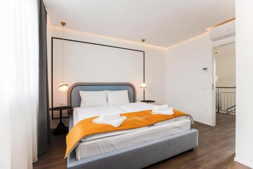 ein Schlafzimmer mit einem großen Bett mit einer orangefarbenen Decke in der Unterkunft The Amberlyn Suite Hotel in Budapest