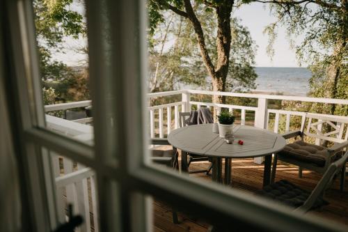 Kaltene的住宿－Jūras māja Ausekļi，阳台的桌椅景窗户