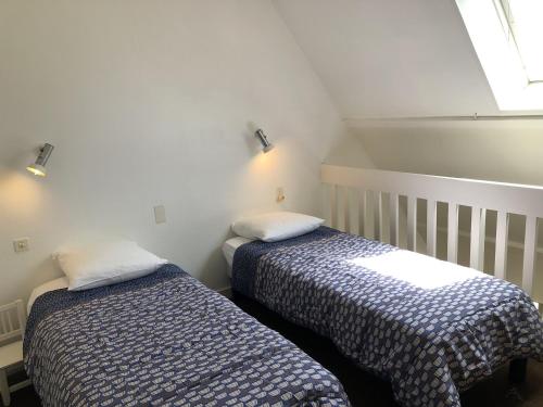 2 Betten nebeneinander in einem Zimmer in der Unterkunft Cromlech, Appartement avec petite vue mer, DT170 in Carnac