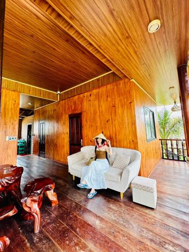 a woman sitting on a couch in a living room at BlackPink Homestay Hồ Tràm in Xóm Trương Quít